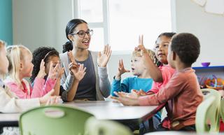 An educator conducts an activity with elementary school children